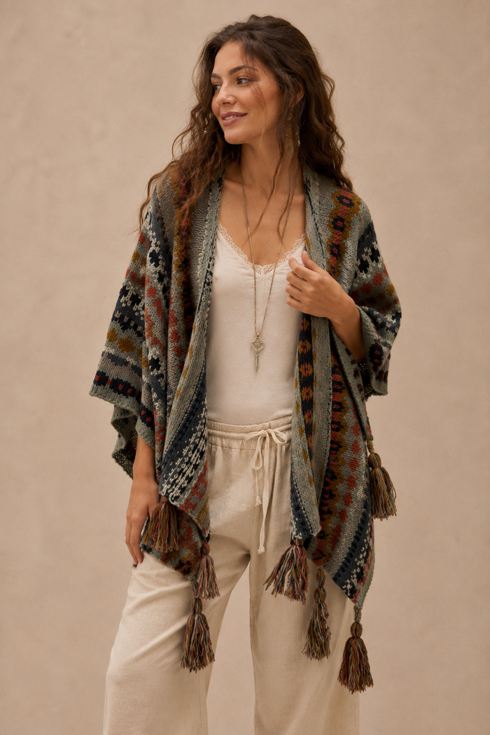 Nordic Grey Wrap worn as a poncho, front view showing V-neckline, fair isle knit and multi-tassel fringe