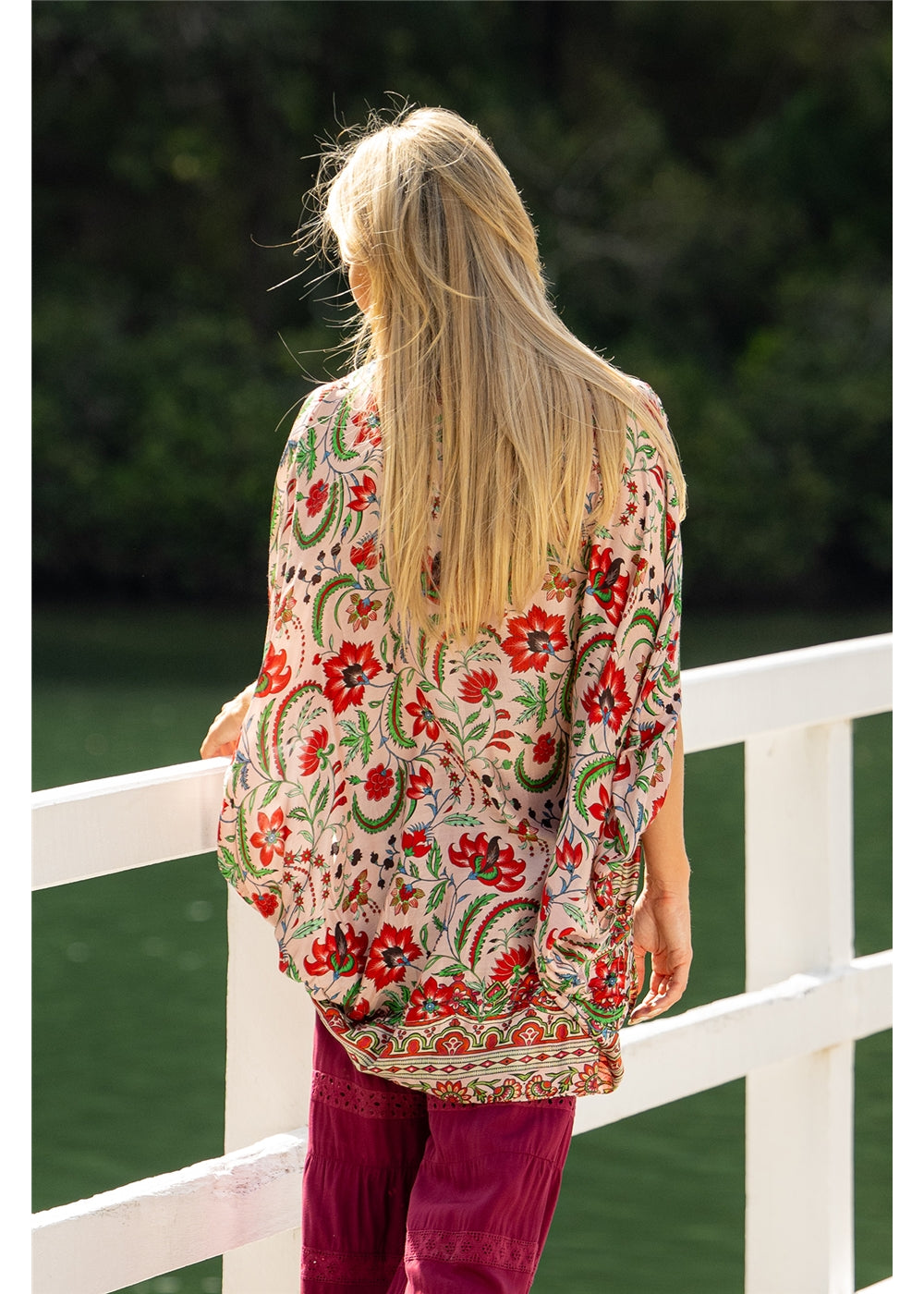 Ada Cape in pink floral silk viscose, back view showing the curved hem and floral border