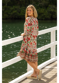 Ada Carmen Dress in pink floral cotton, three-quarter back view beside the water