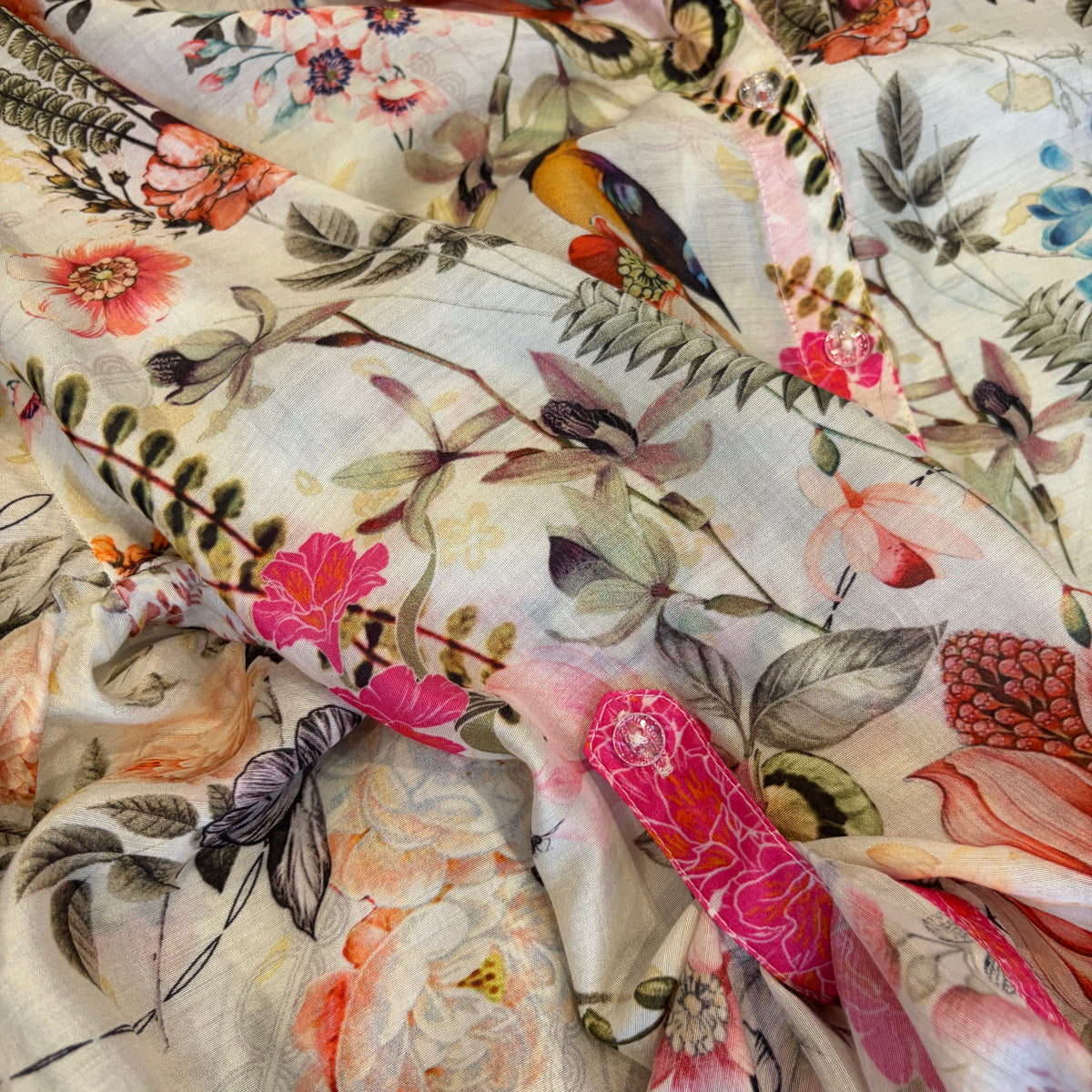 Birdsong Shirt in ivory bird-and-floral silk viscose, close view of the pink cuff tab, clear buttons and front placket.