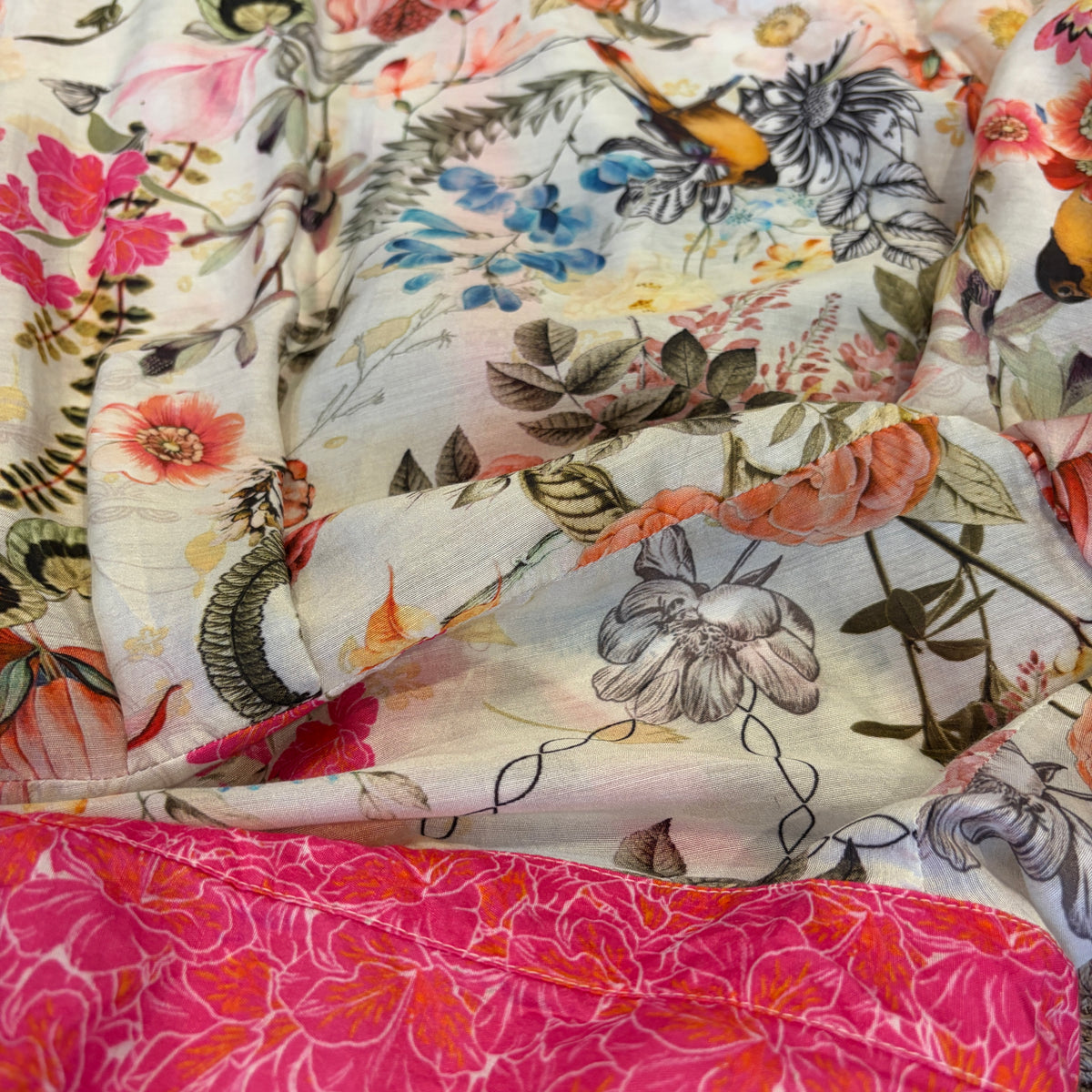 Birdsong Shirt in ivory silk viscose with pink flowers, blue foliage and birds, close view of the fabric.