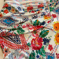 Cita Jumpsuit in ivory floral print viscose rayon, close view of gathered fabric with red roses, blue motifs and green leaves