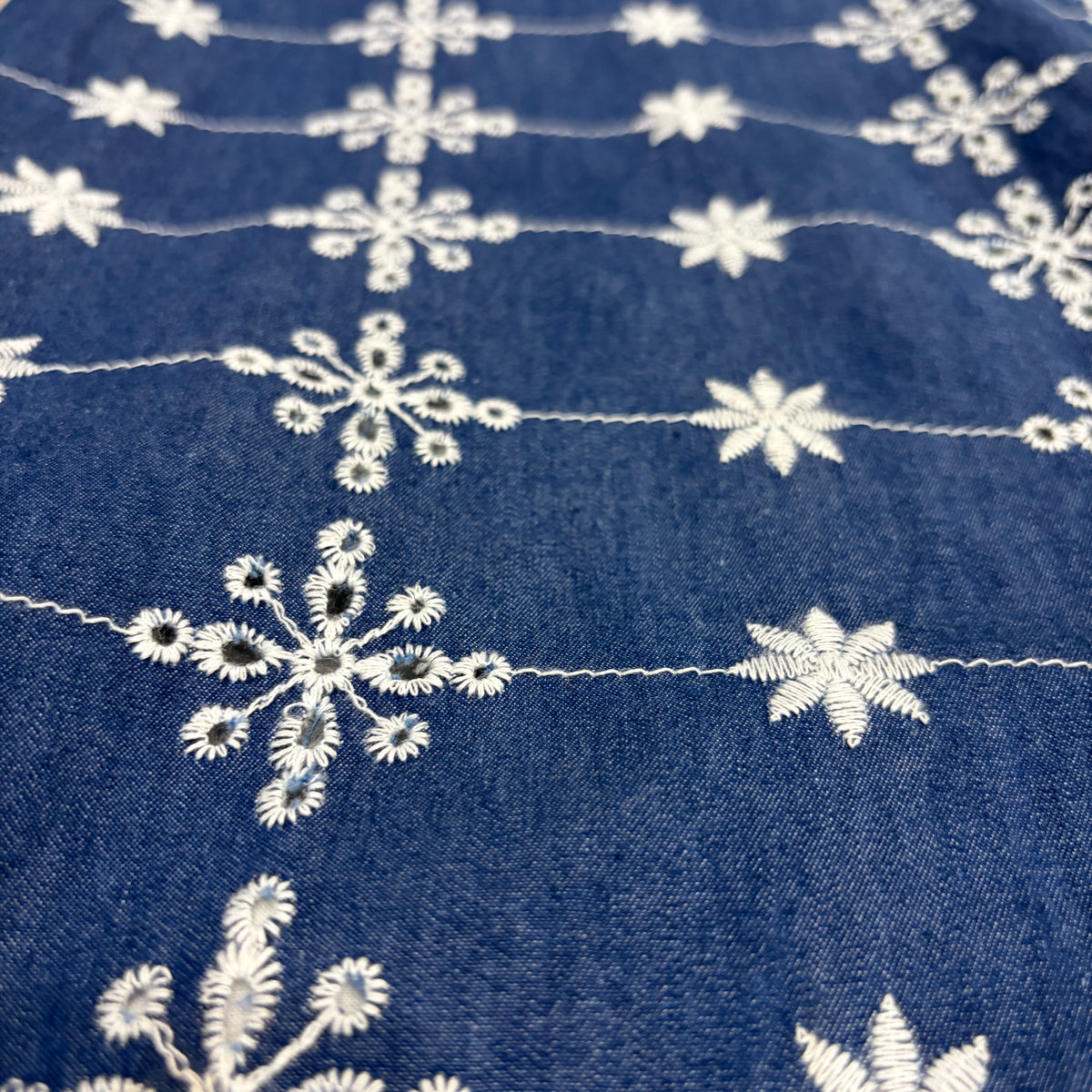CJ-08 Floral Embroidered Jeans in indigo cotton denim, close view of the fabric and floral eyelet embroidery