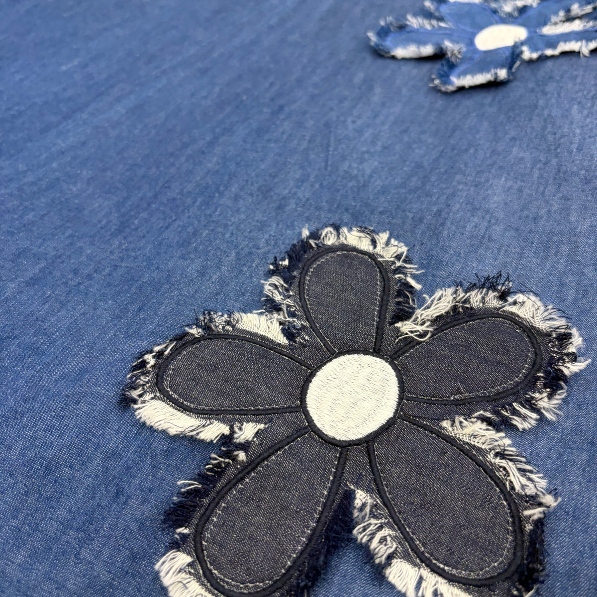 CJ-09 Denim Lace Shirt Dress in blue cotton denim, close view of the fabric and frayed floral appliqués