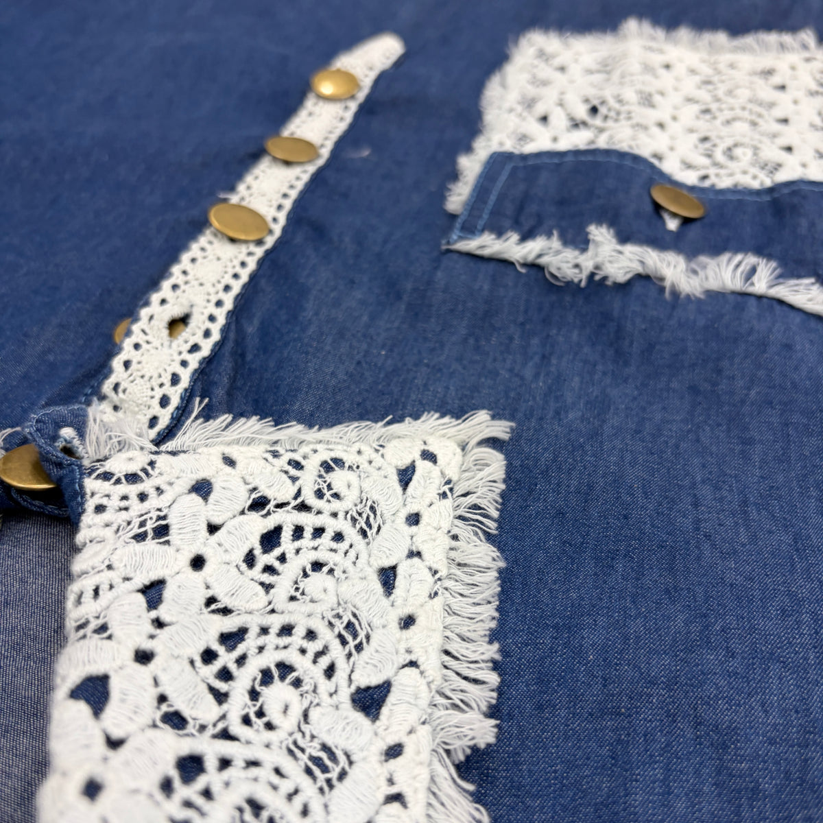 CJ-09 Denim Lace Shirt Dress in blue cotton denim, close view of the white lace collar, chest pocket and gold-tone buttons