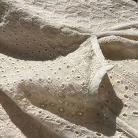 CJ-117 Top in natural cream, close view of the notched neckline and oval eyelet embroidery