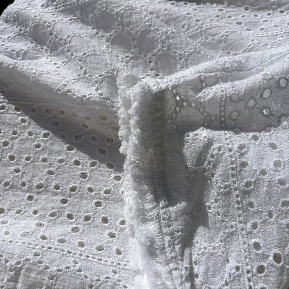 CJ-117 Top in white, close view of the embroidered fabric and fringed sleeve edge
