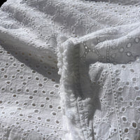 CJ-117 Top in white, close view of the embroidered fabric and fringed sleeve edge