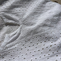 CJ-117 Top in white, close view of the notched neckline and oval eyelet embroidery