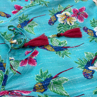 CJ-165 Bird Long Dress in turquoise blue cotton, close view of the magenta tassel ties and parrot print fabric