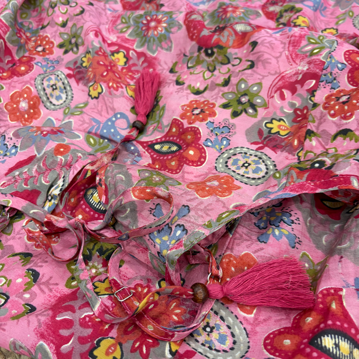 Close-up of the pink tassel ties and floral fabric on the CJ-165 Floral Long Dress