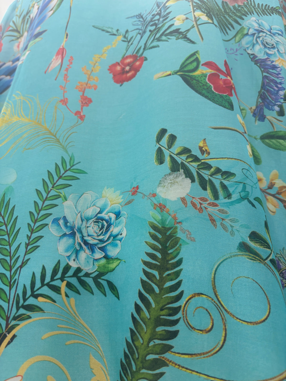 Turquoise Reverie Duster in turquoise with blue flowers and green foliage, close view of the fabric