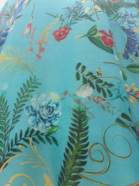 Turquoise Reverie Duster in turquoise with blue flowers and green foliage, close view of the fabric