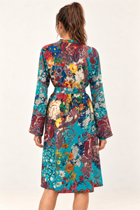 Zahara Dress in turquoise floral and paisley print, back view showing the waist tie and long sleeves.
