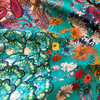 Zahara Dress fabric detail showing flowers and paisley motifs in ivory, green, orange and blue on turquoise.