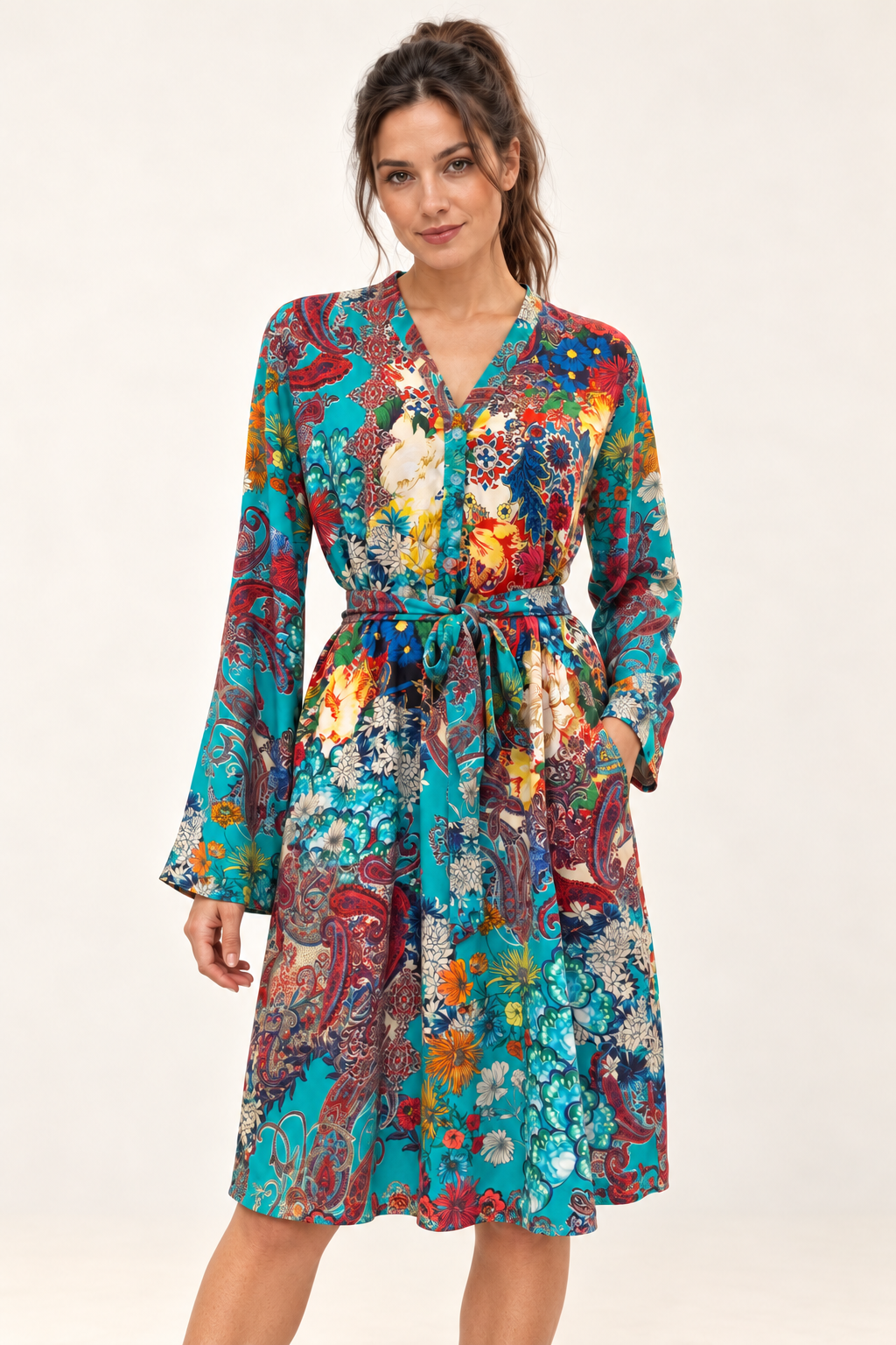 Zahara Dress in turquoise floral and paisley print, studio front view showing the tied waist and long sleeves.