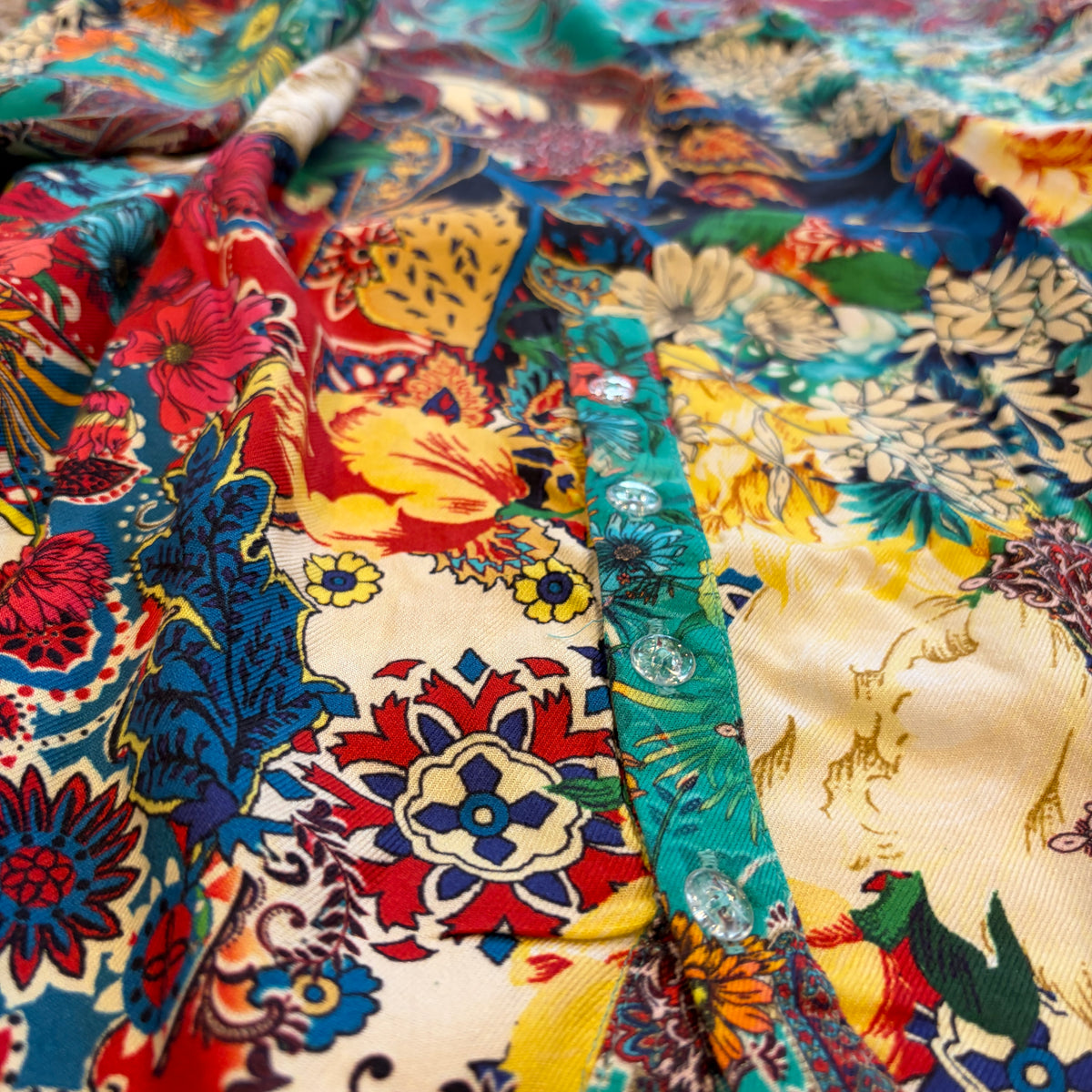 Zahara Dress in turquoise, red, yellow and ivory floral print, close view of the button placket.