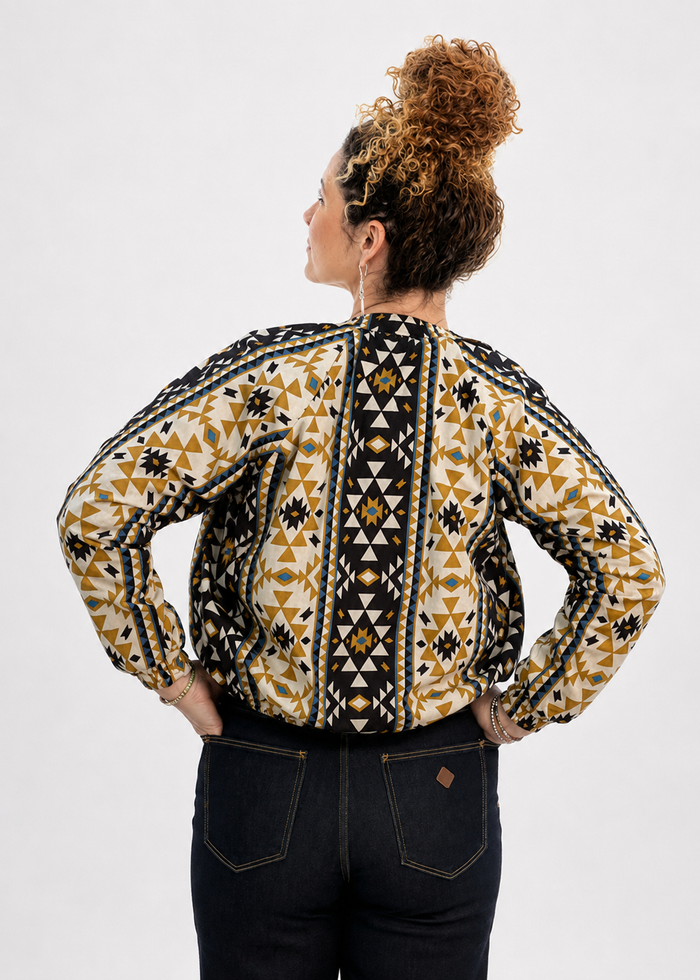 Coyote geometric print reversible bomber jacket back view showing navy base with high contrast gold mustard geometric pattern - Cienna Designs