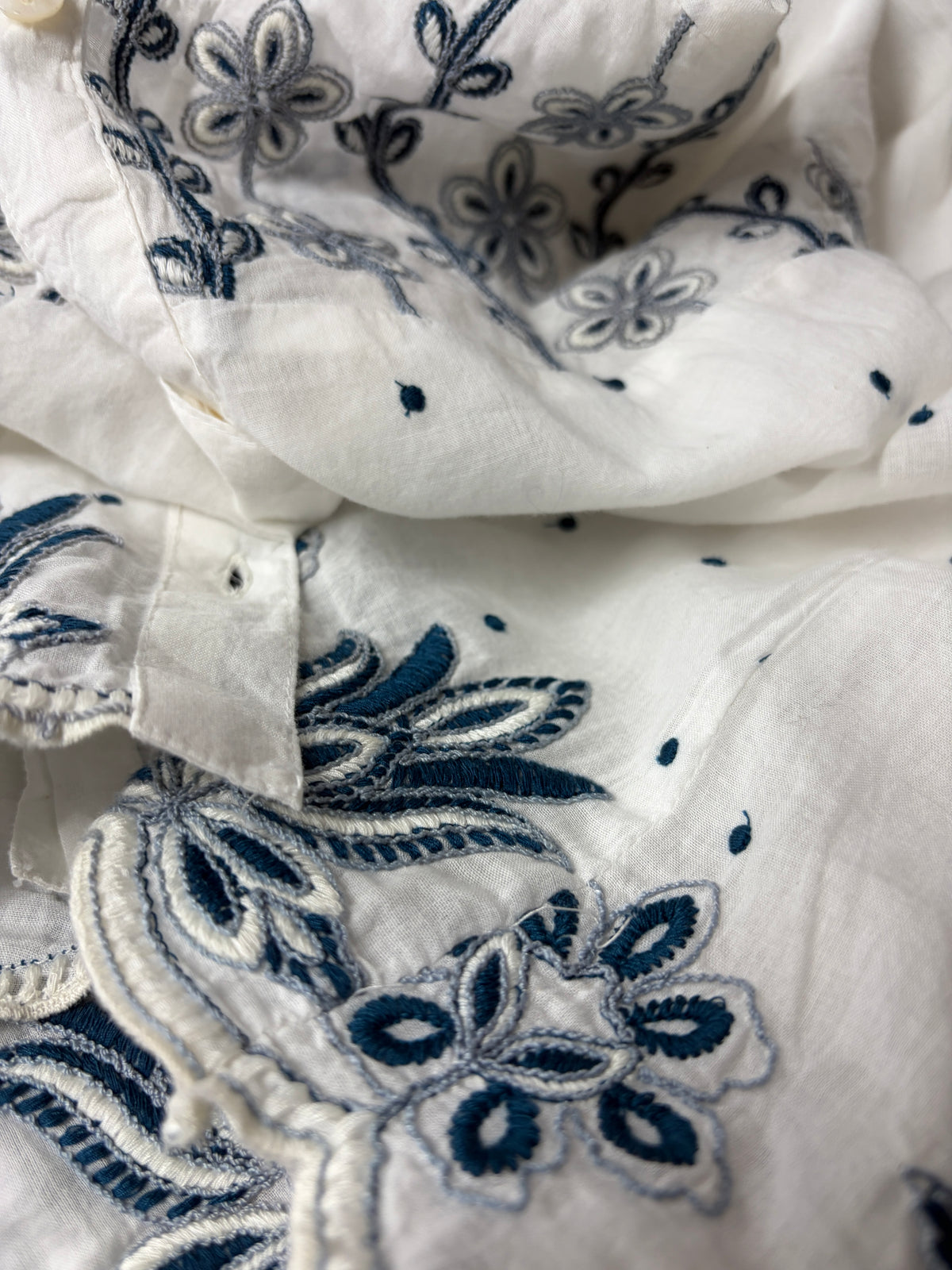 Phoebe Top close-up showing navy embroidery across the yoke and scalloped hem detail on 100% cotton - Cienna Designs