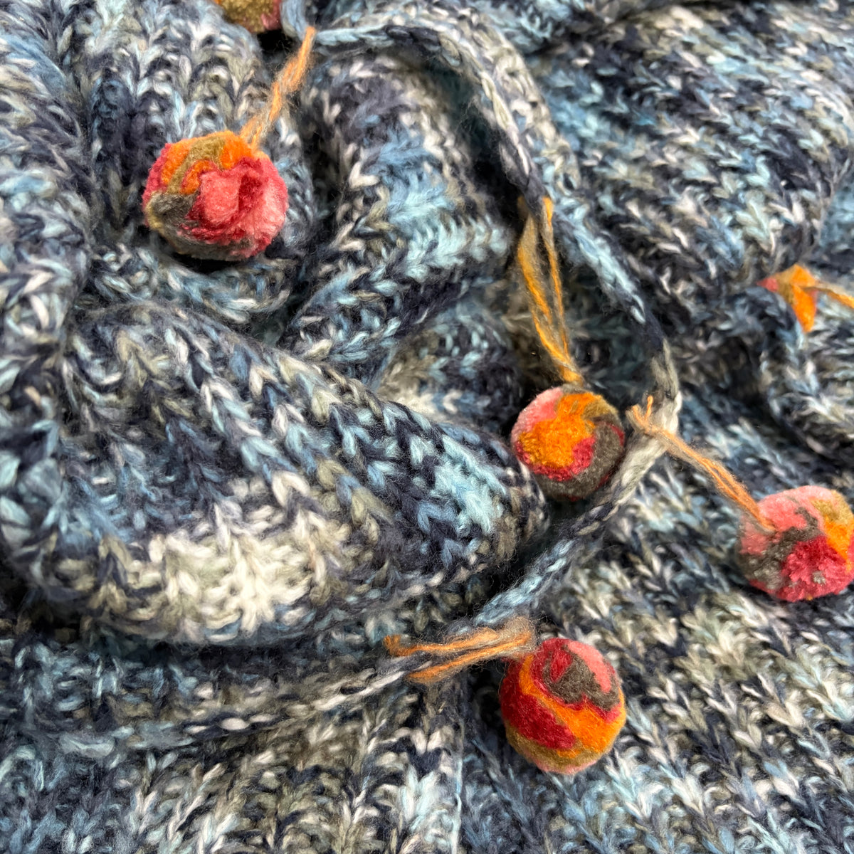 Pompom Wrap blue knit texture and pompom tassel detail closeup