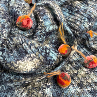 Pompom Wrap blue knit texture and pompom tassel detail closeup