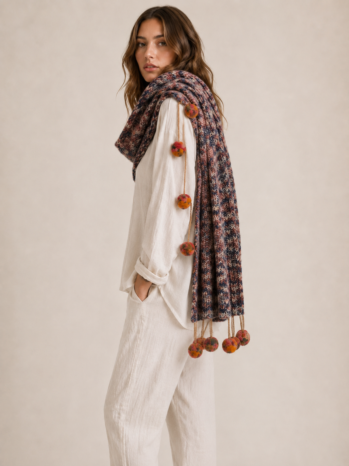 Pompom Wrap blush knit draped over shoulders as shawl