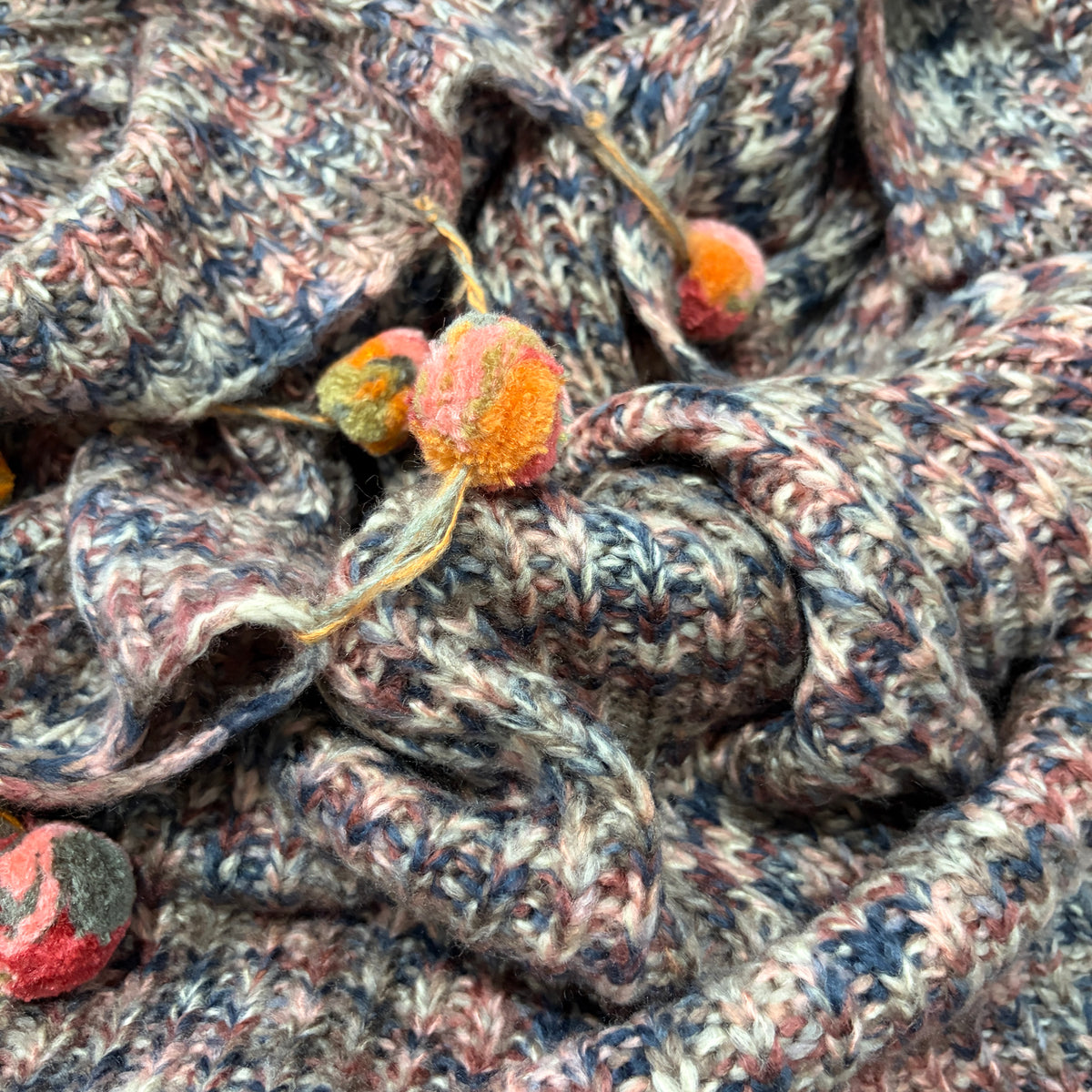 Pompom Wrap blush pink colourway fabric closeup with multicolour pompom tassels