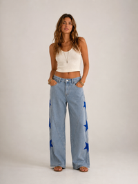 Star Pearl Denim Jeans Light Wash - front view, wide-leg light wash denim with large cobalt blue star appliqués and pearl trim