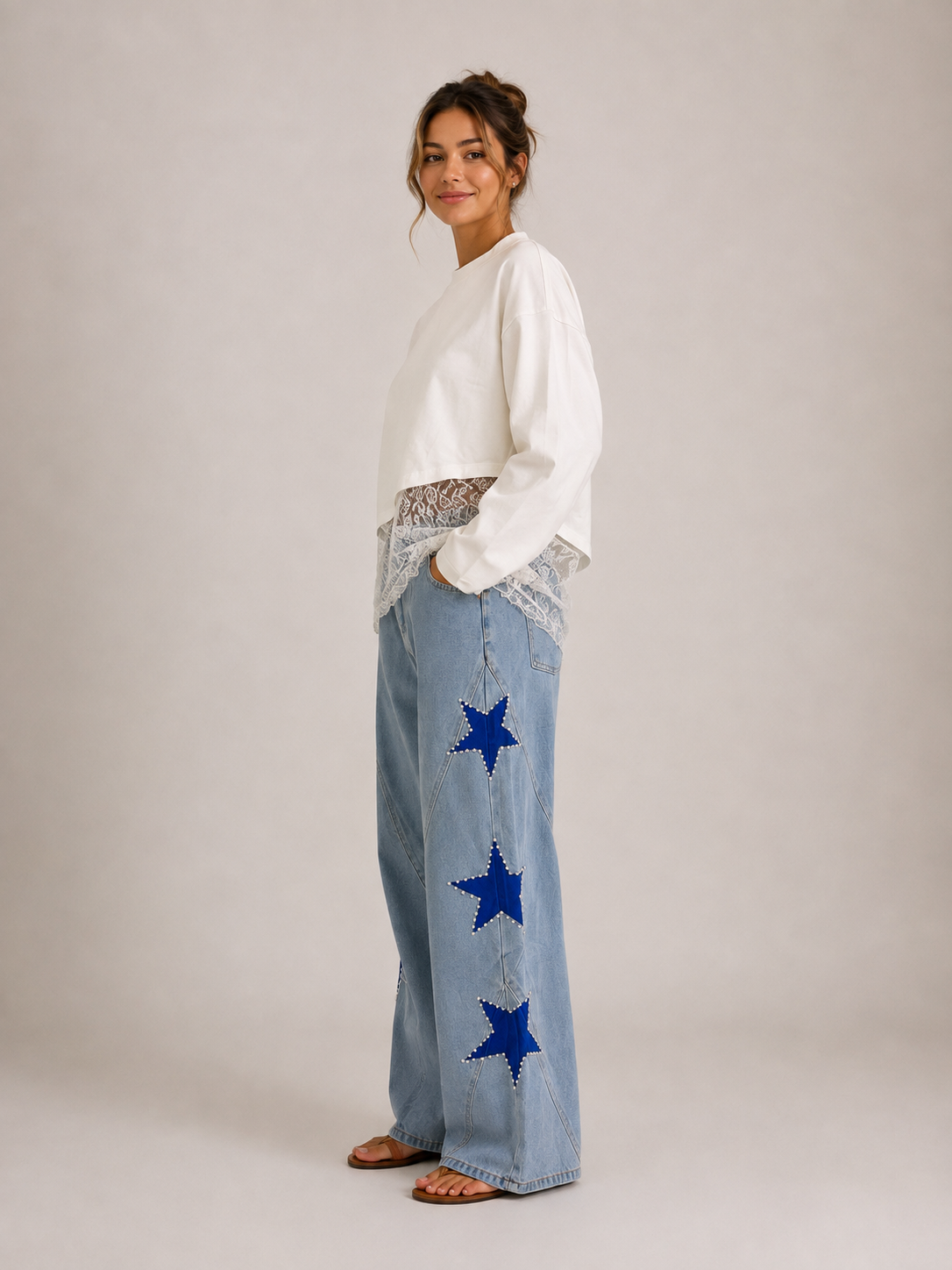 Star Pearl Denim Jeans Light Wash - styled with Lace Hem Top White, three-quarter side view showing wide-leg silhouette and blue star appliqués