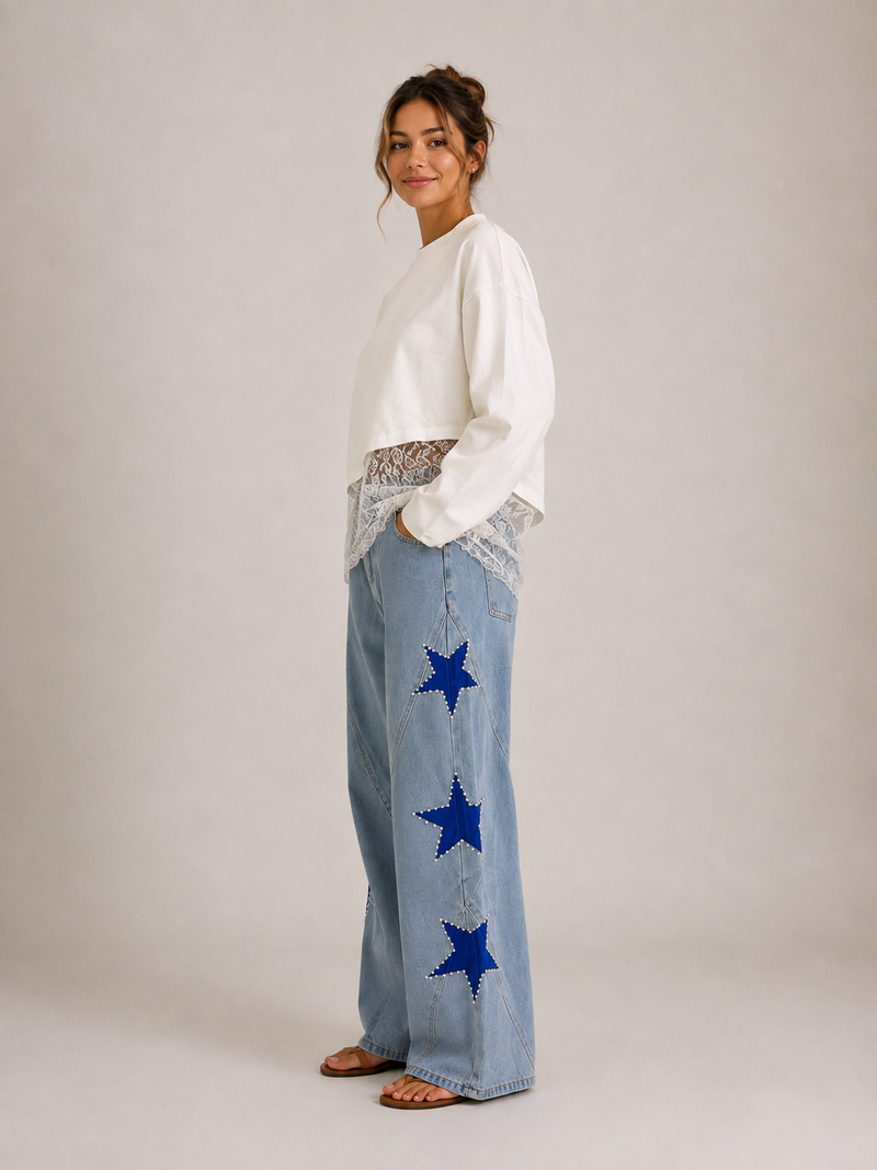 Star Pearl Denim Jeans Light Wash - styled with Lace Hem Top White, three-quarter side view showing wide-leg silhouette and blue star appliqués