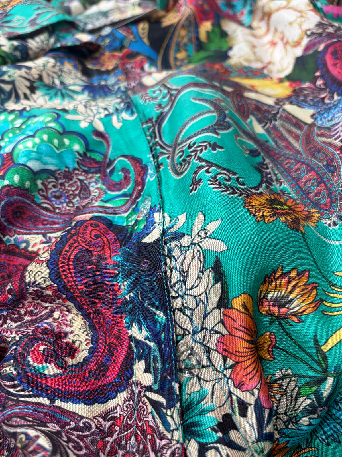 Close-up of Stef Silk Shirt showing bold paisley and floral print in vibrant teal and burgundy on fluid semi-sheer silk-viscose blend - Cienna Designs