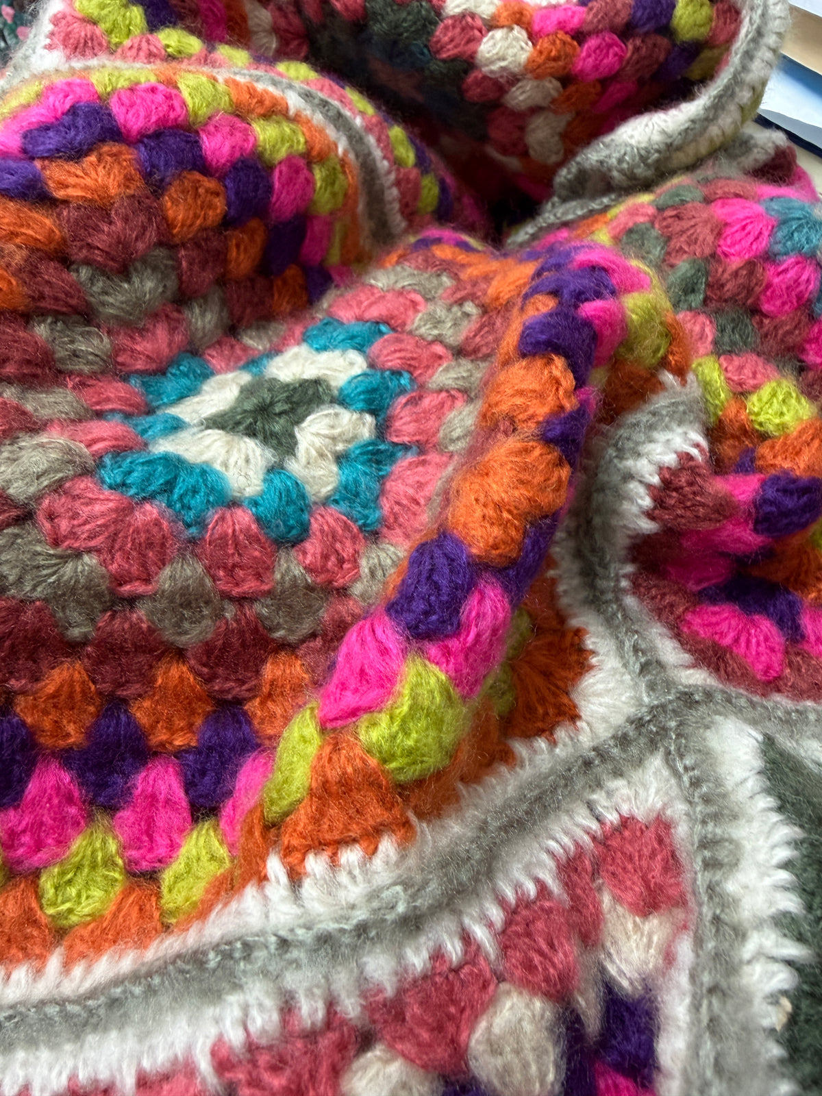 Close-up of Sunset Mosaic Crochet Poncho showing handcrafted granny square crochet in warm sunset tones with teal and lime accents - Cienna Designs