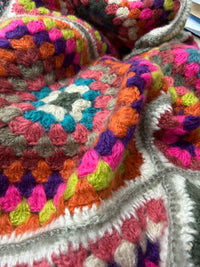Close-up of Sunset Mosaic Crochet Poncho showing handcrafted granny square crochet in warm sunset tones with teal and lime accents - Cienna Designs