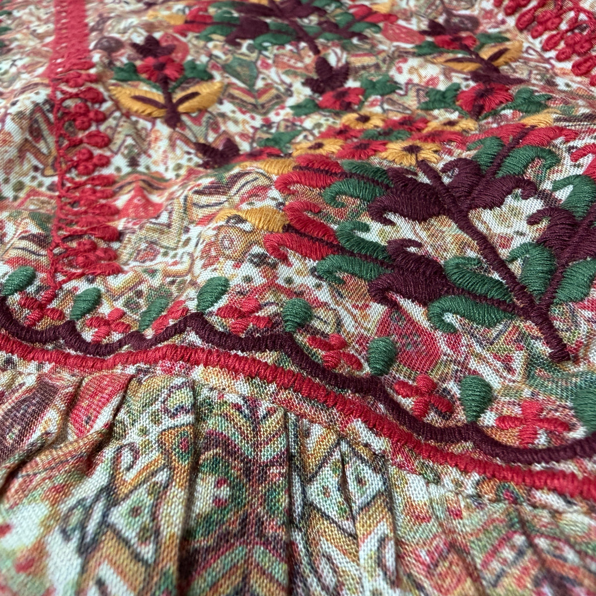 Close-up of Vintage Fold midi dress showing richly printed folk floral pattern and intricate hand embroidery on rayon - Sample D-1365 by Cienna Designs