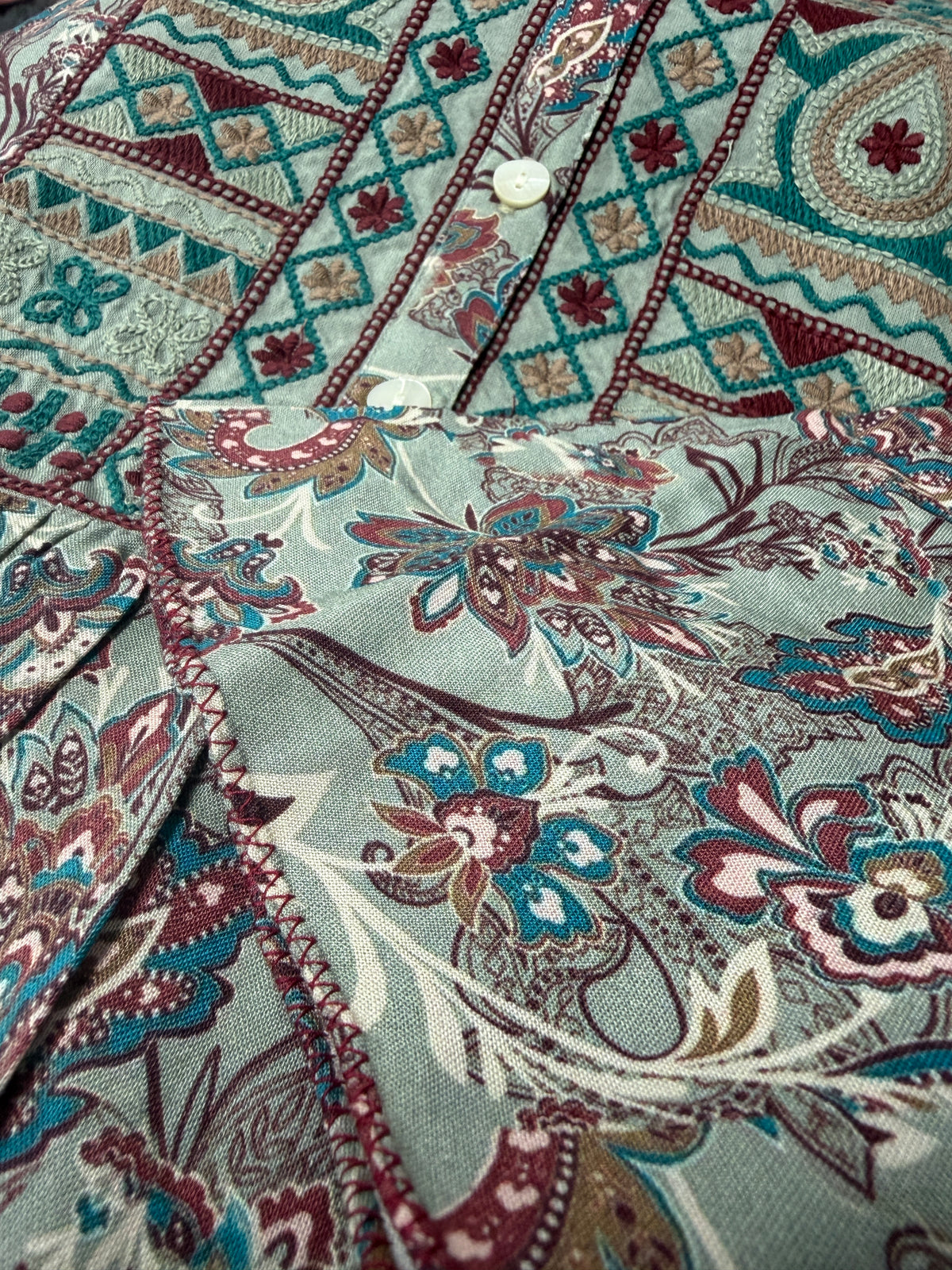 Close-up of Willow Paisley dress embroidered front panel showing delicate paisley and floral motifs - Sample D-1528 by Cienna Designs